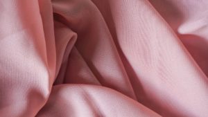 Wrinkled, pink sheet of poly-cotton fabric